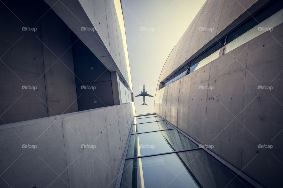 Corporate modern buildings skyline with airplane flying overhead. High rise skycrappers.