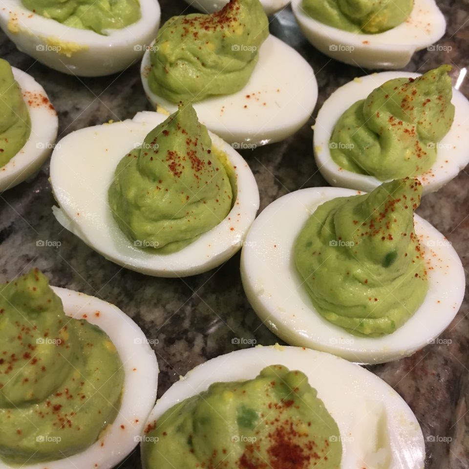 Avocado deviled eggs, with paprika sprinkled on top. 
