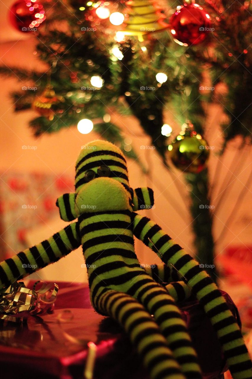 Child’s toy sock monkey under a Christmas Tree