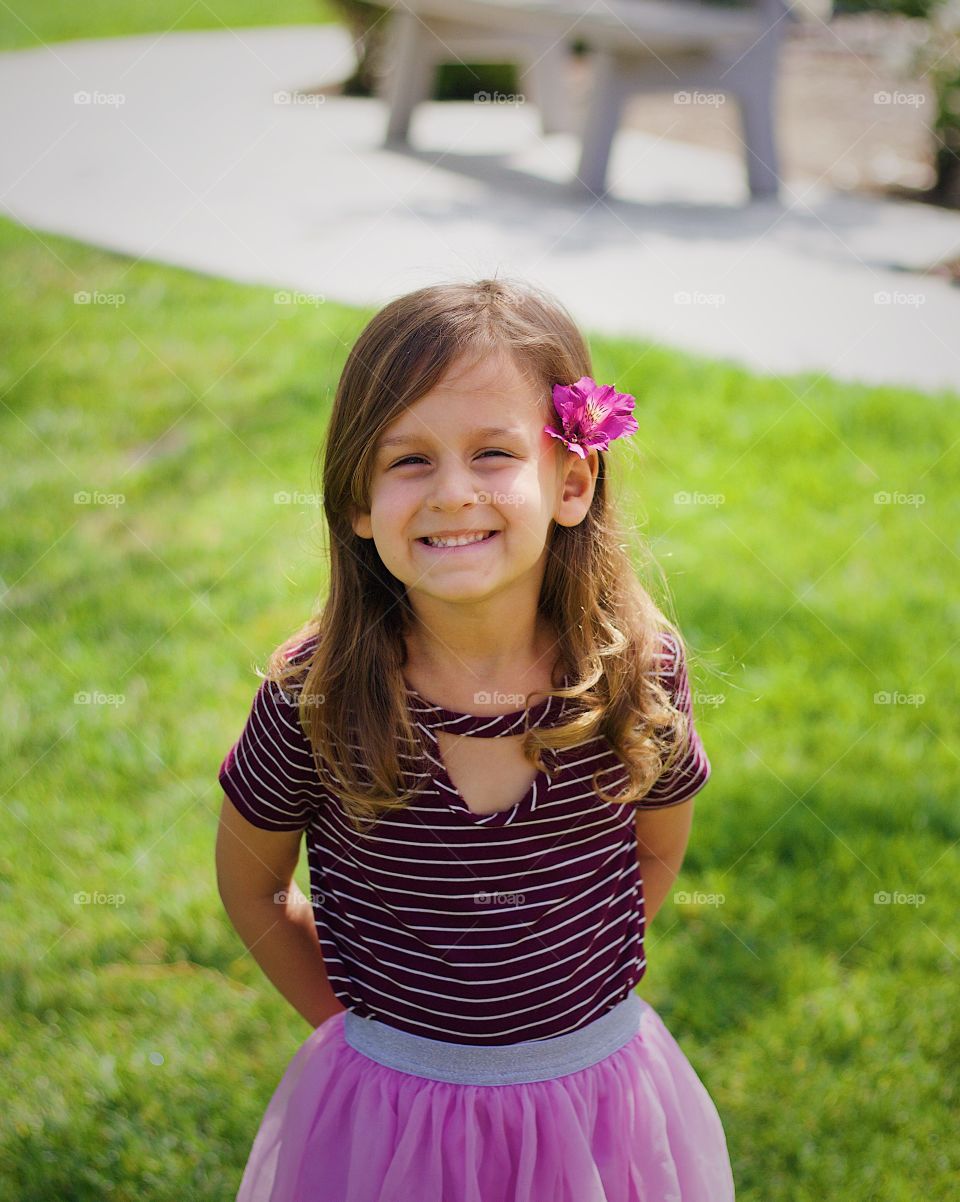 Four year old smiling with a flower in her ear