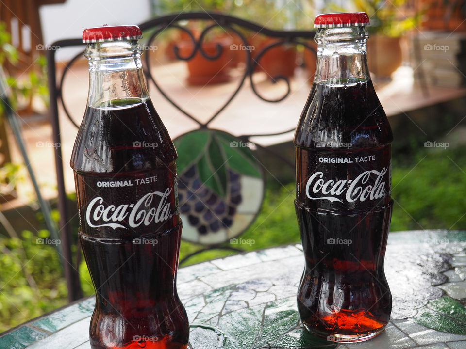 Coca Cola bottles on garden table.