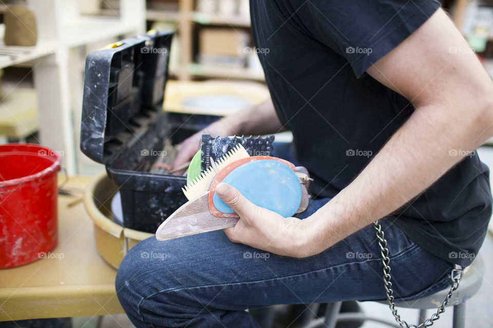 Dress for Mess. An artist prepares his pottery wheel. 
