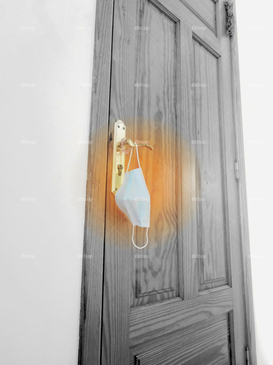 surgical mask on the doorknob of the front door of a house