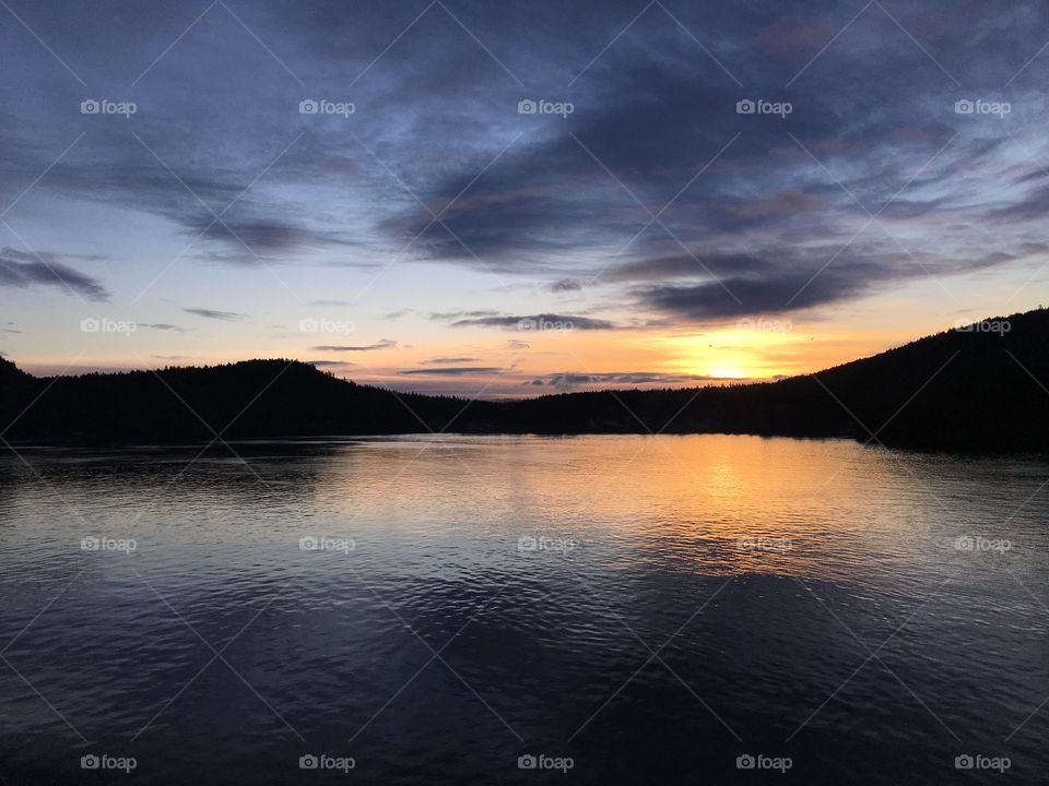 View of stormy clouds reflecting on lake