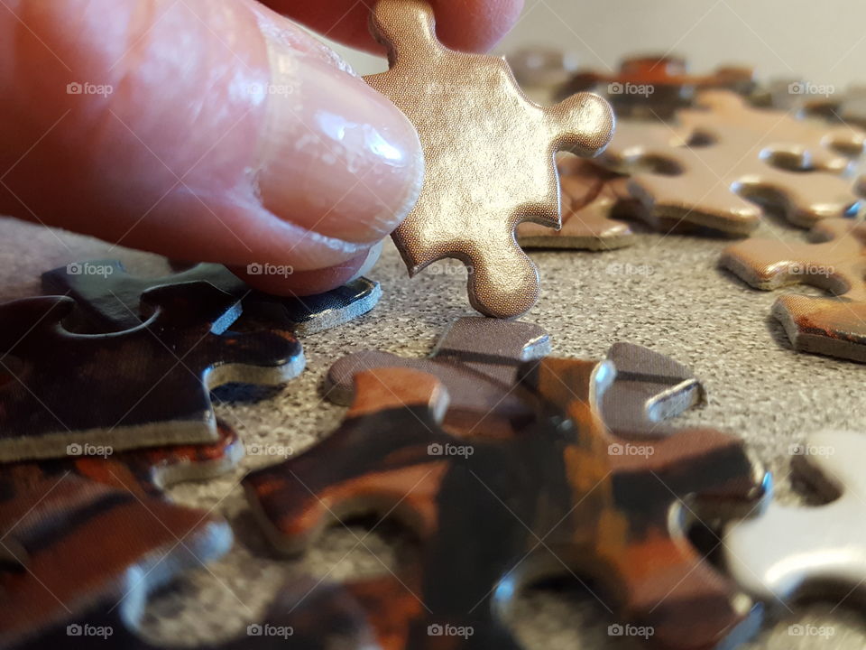 Close-up of human hand with jigsaw piece