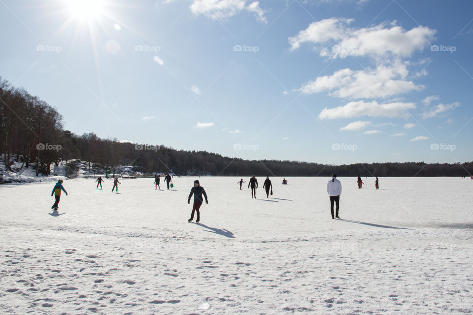 Ice skating on frozen lake on a sunny cold winter day 