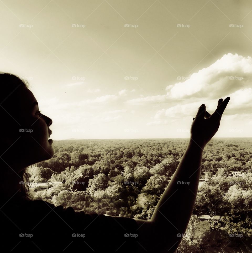 Girl reaching for the clouds 