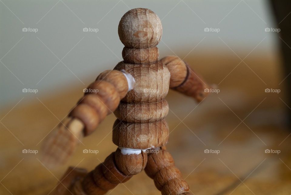 A wooden sculpture of a man used for drawing and sketching appears to be running a race.