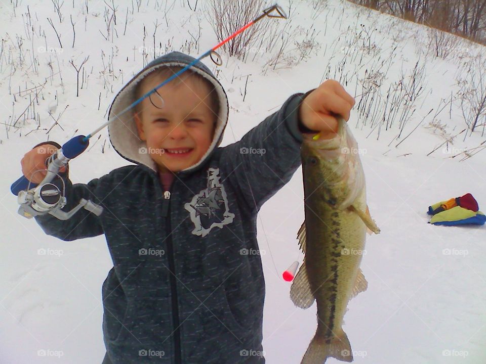 Ice fishing boy with bass