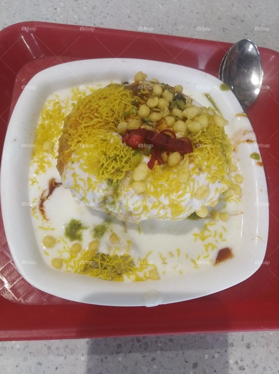 a namkeen dish with curd and yellow bhujiya chatni soce very tasty and looks very beautiful