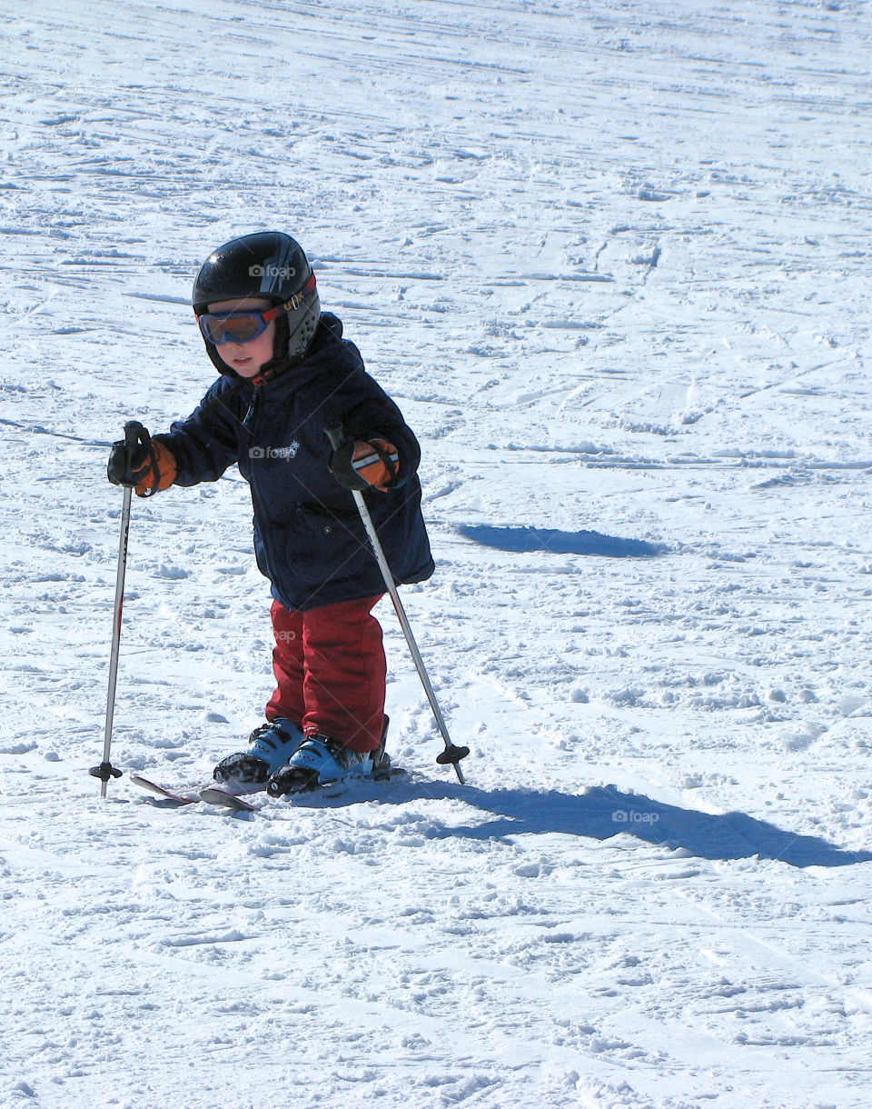 Little child learns skiing
