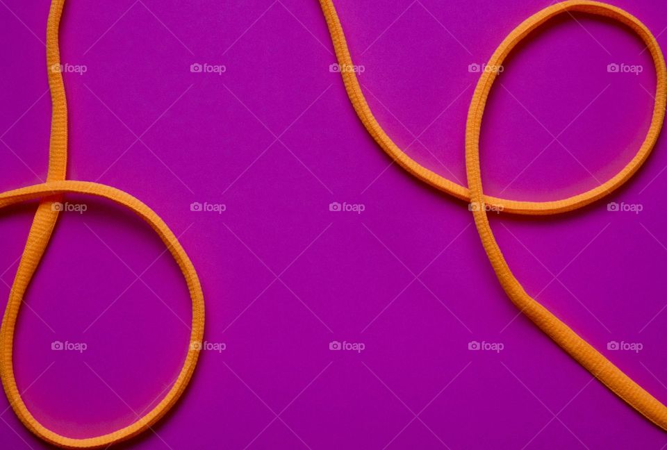 Neon orange nylon cord on a bright fuchsia background 