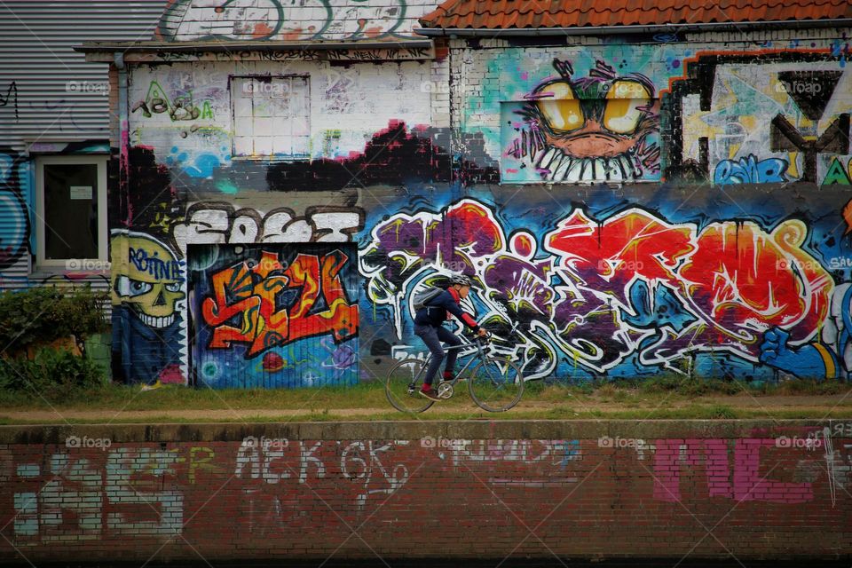 cyclists in front of graffiti