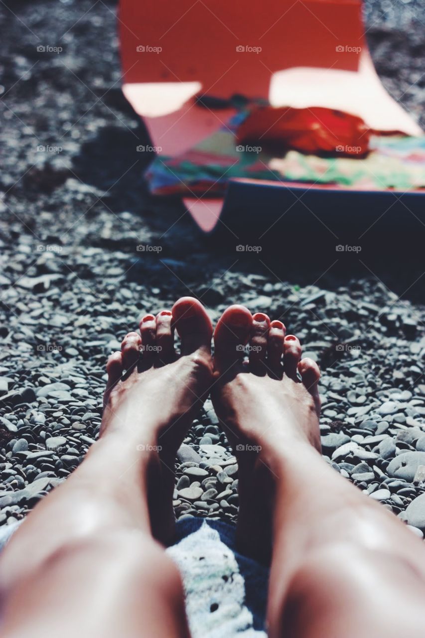 Feet at the sunny beach 