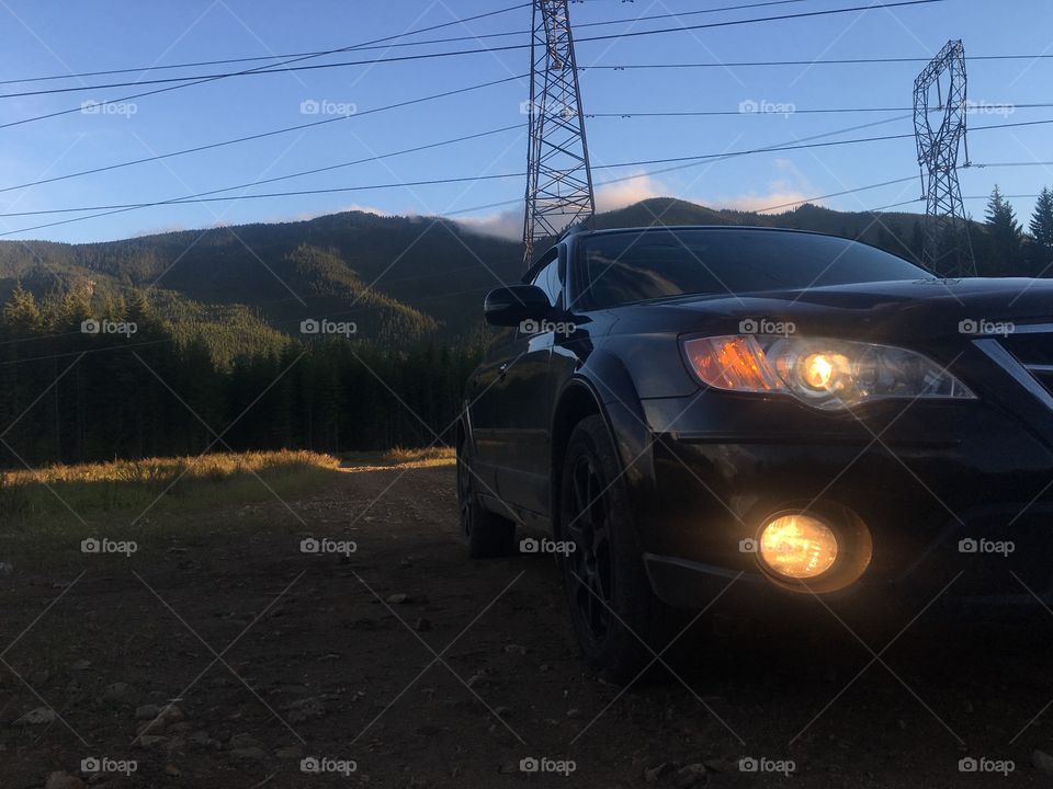 Subaru Outback with lights on in the mountains