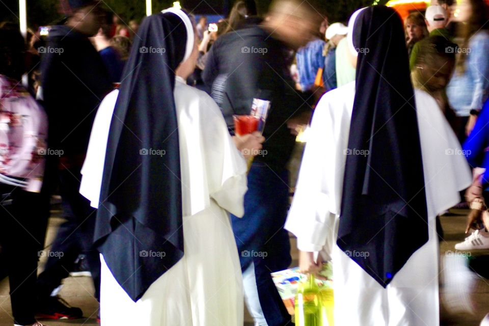 Two nuns stand out in a crowded room of faceless people!
