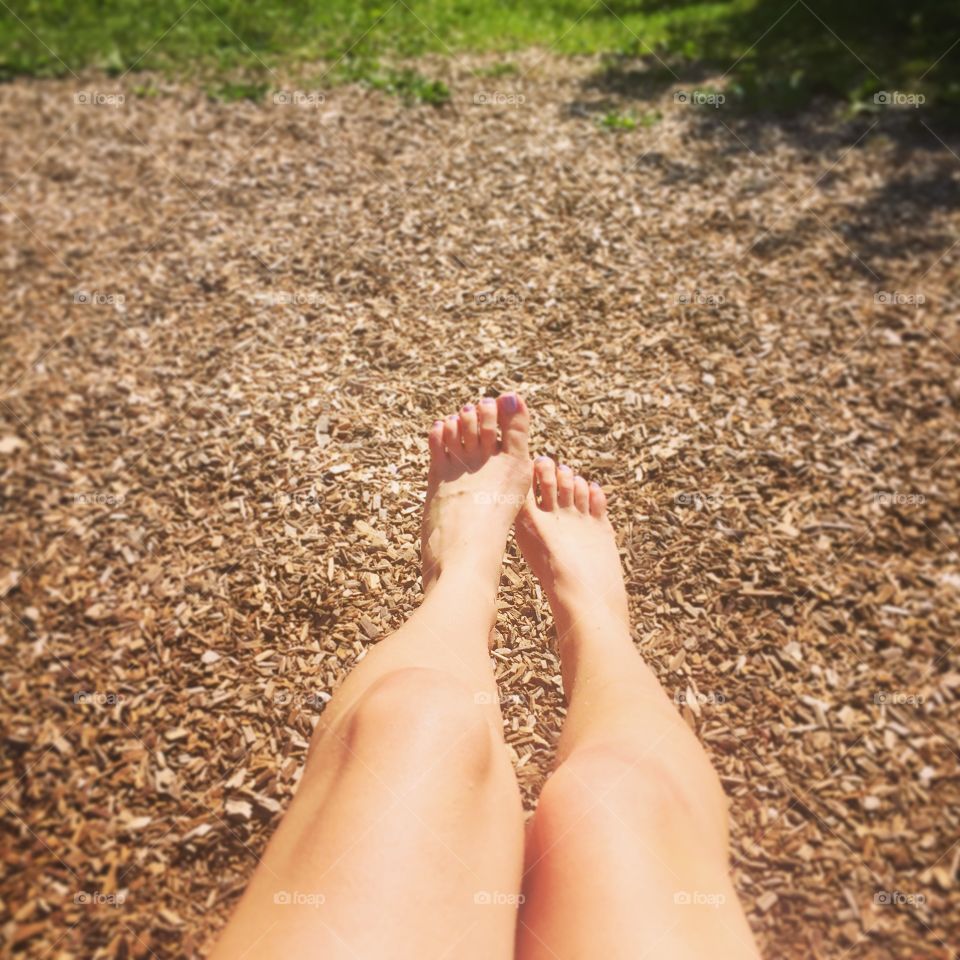 POV legs on a swing on a sunny summer day