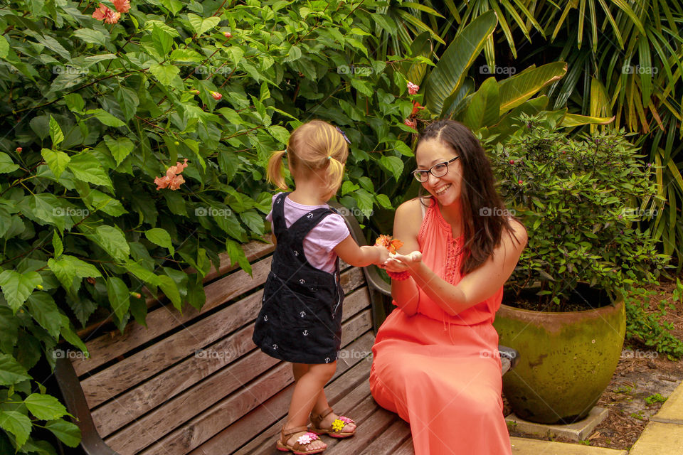 Little girl giving flower to her mother