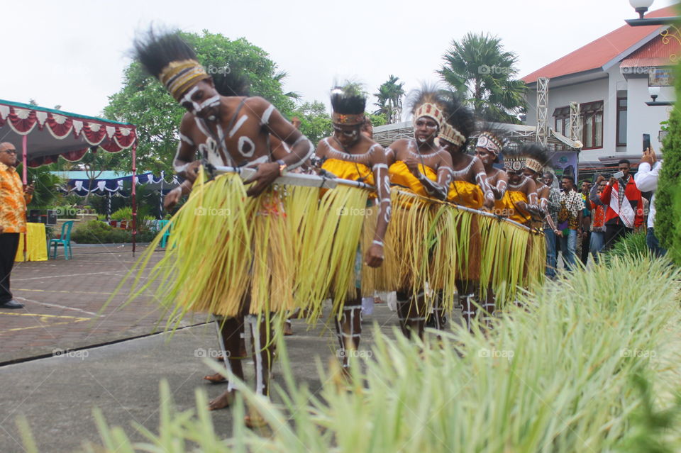 Boys and girls of Kamoro tribe use traditional clothing and dance.