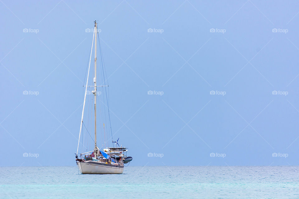The yacht floats calmly in the sea on a windless day.