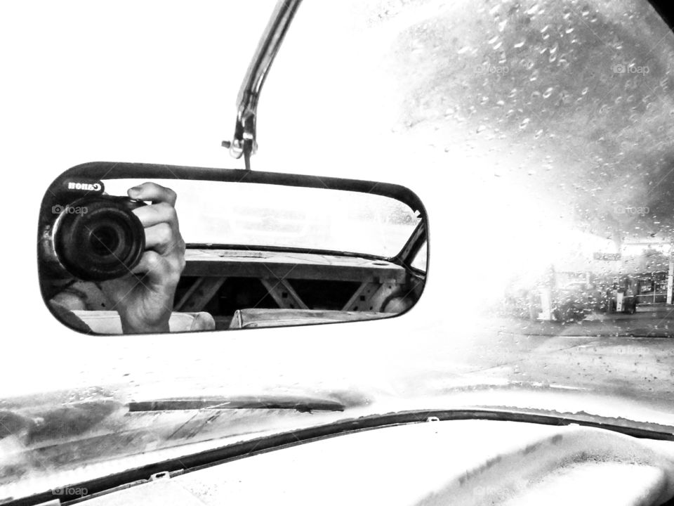 black and white camera reflection in mirror of vintage car