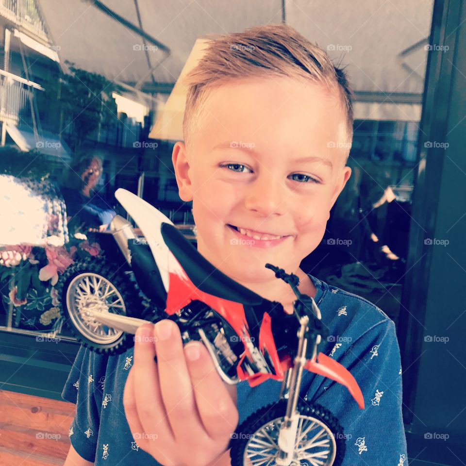 Swedish boy with his toy motorcycle on a balcony