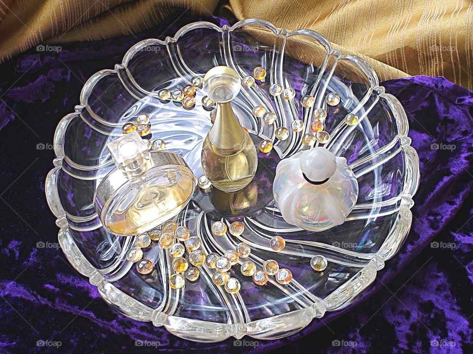 Perfume on a glass bowl on a wood table