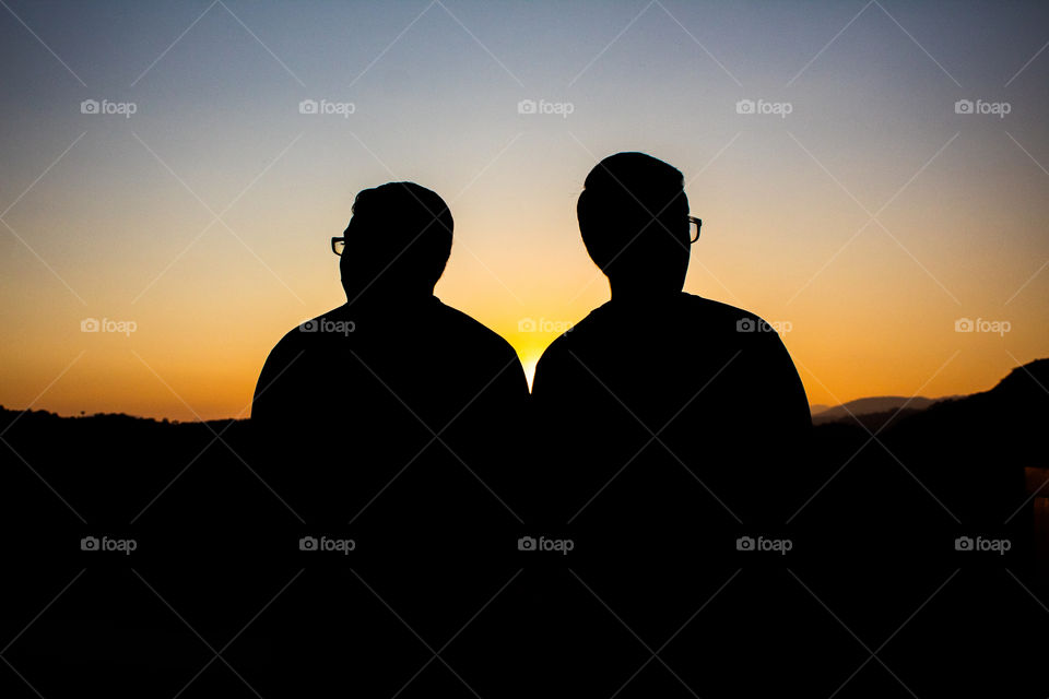 Two brothers looking at the horizon at golden hour.