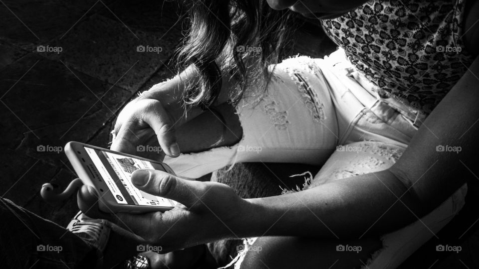 Menina digitando, navegando na internet por celular.