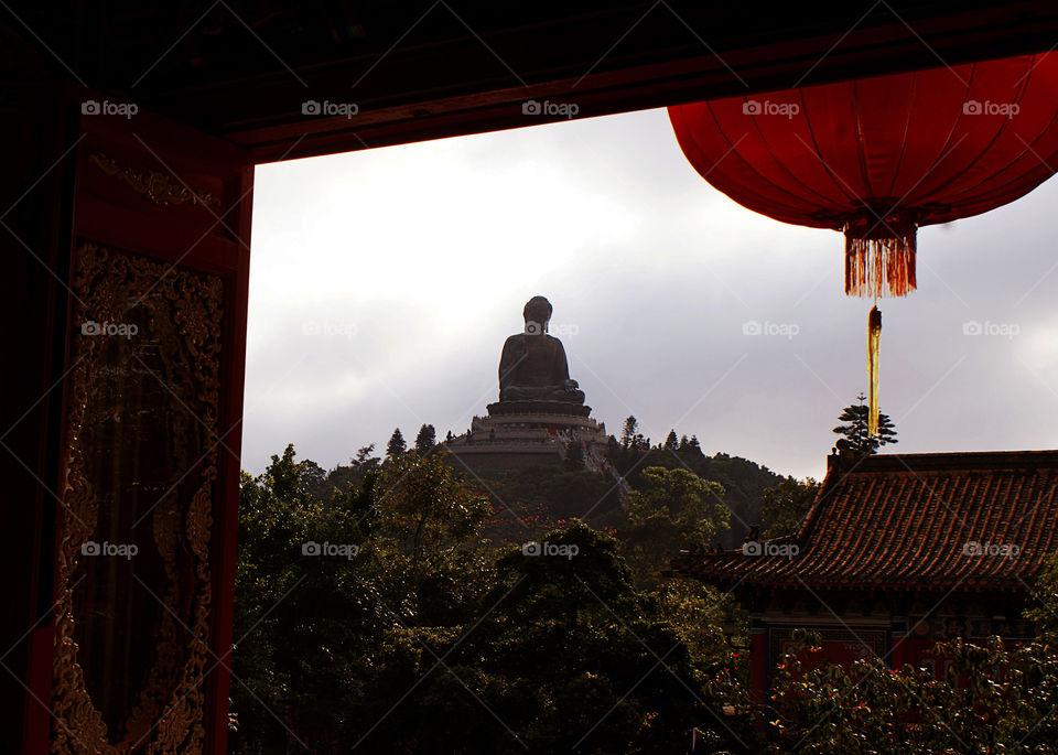 Unique moment from the window of the temple at Lantau island in Hong Kong . Big Buddha 