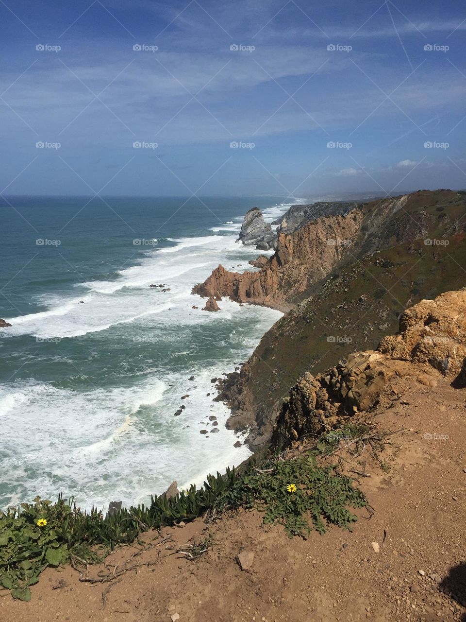 Cabo da Roca, Portugal, the Europe westernmost point. Foamy ocean waves crashing against rock cliffs 