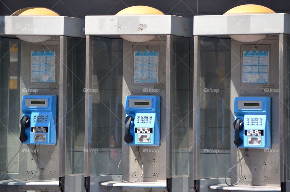 Three public telephones on a square in Antwerp.