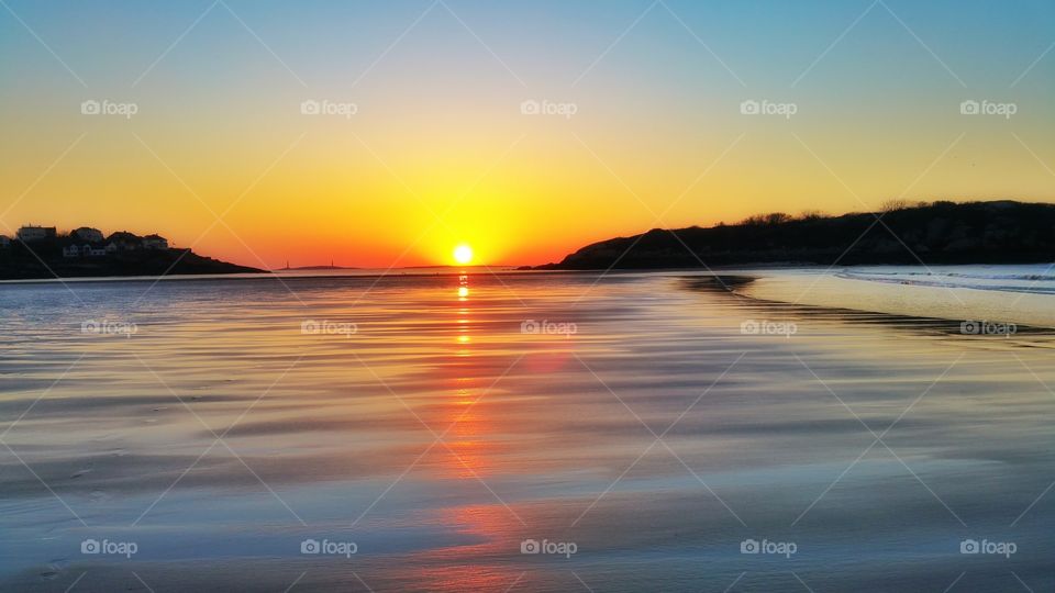 reflections. bright sunrise reflects on the bare beach