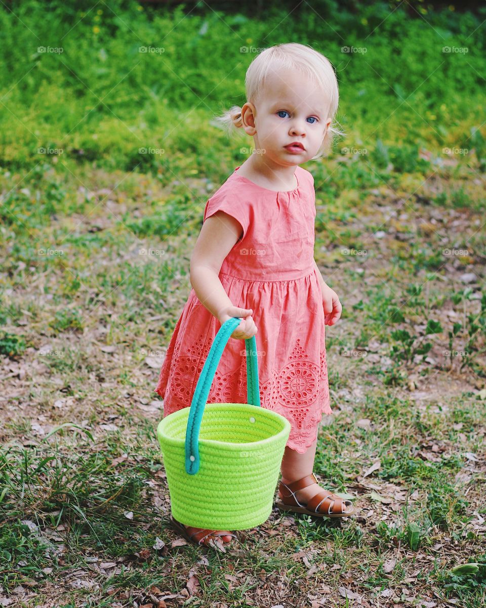 Beautiful Baby girl Easter egg hunting who stops to give her model look