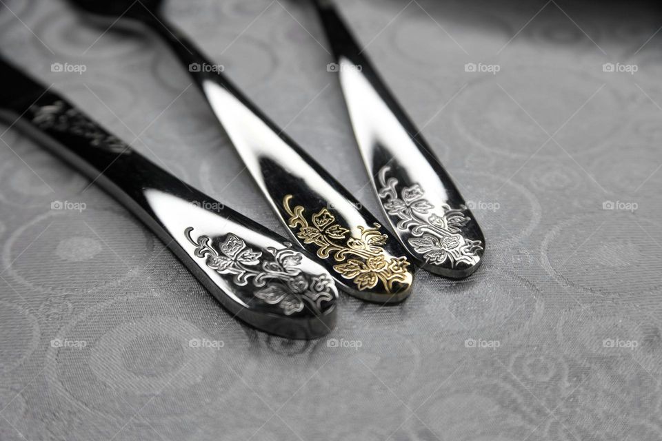 black and white photo set of fork spoon knife with a pattern on the handle