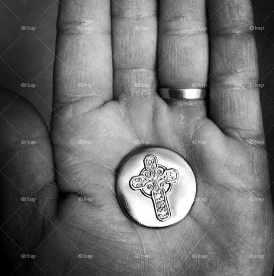 A silver Celtic coin in a distressed hand