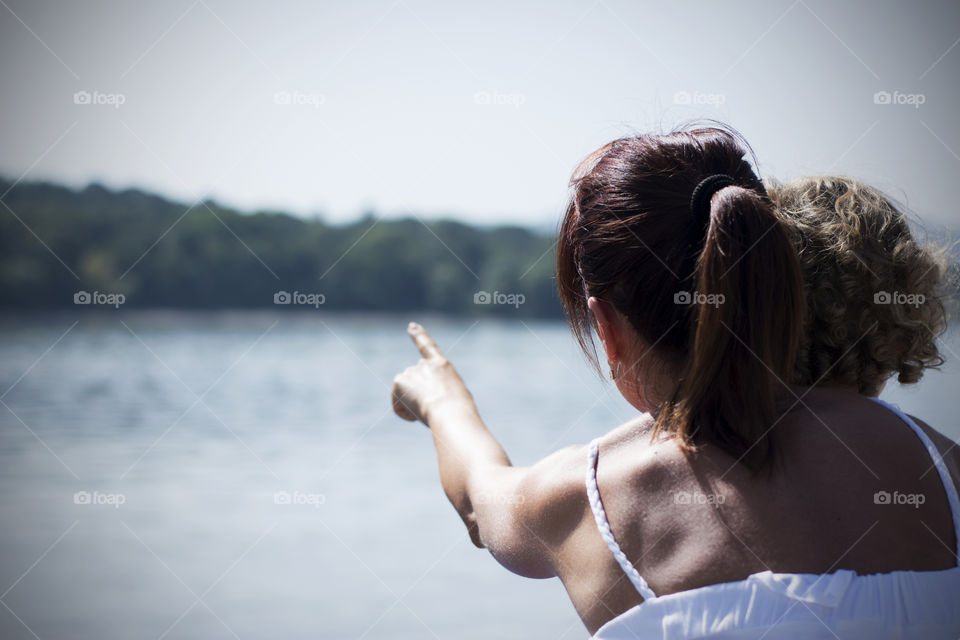 mother showing her child river. young mother showing her child river