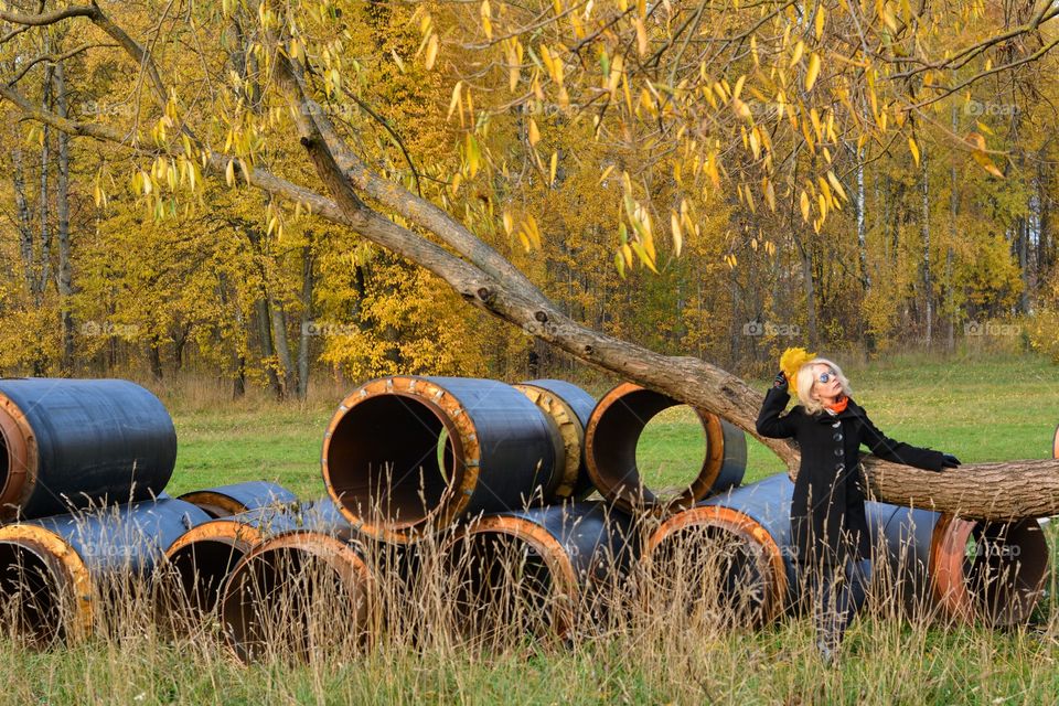 woman relaxing in the autumn park and tubes building beautiful nature landscape