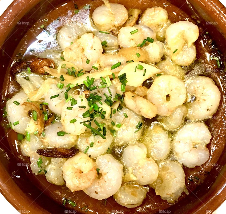 Shrimps fried with garlic and olive oil served on a hot plate. Spanish traditional tapas