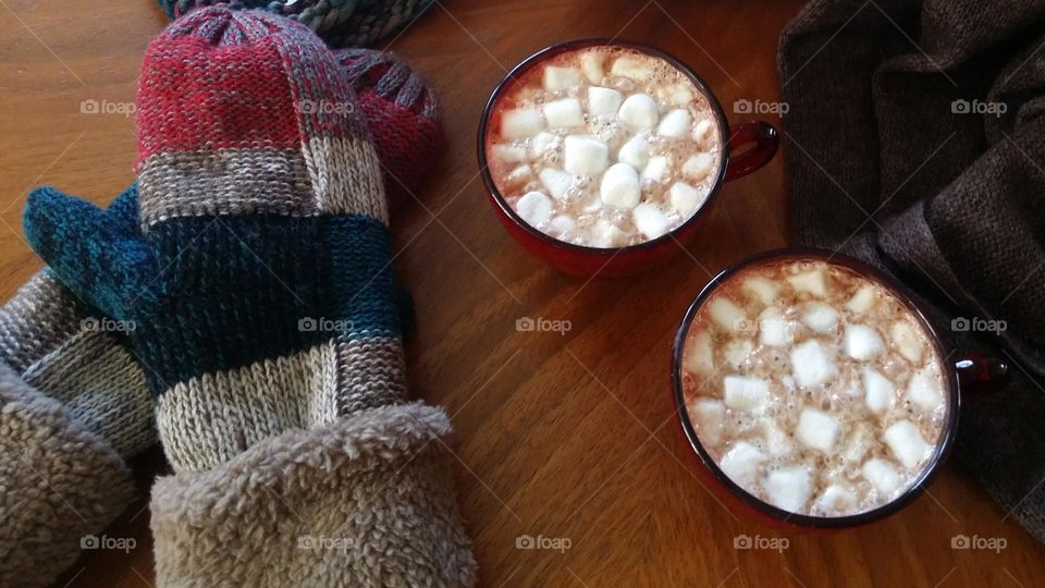 Hot Cocoa & warm mittens in a wooden table winter essentials