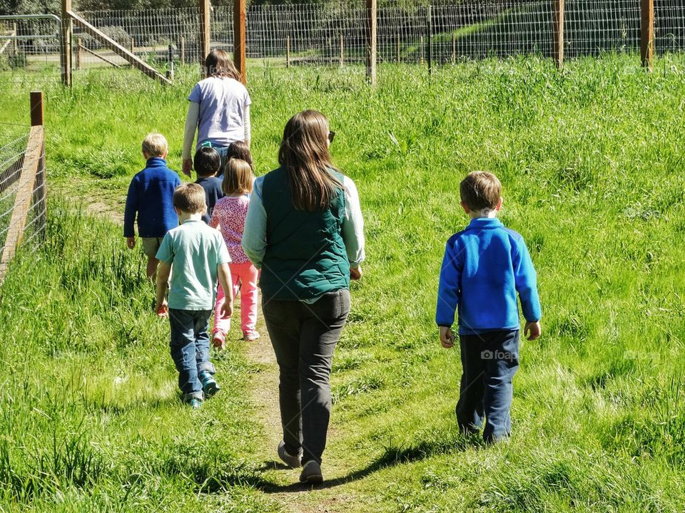 Farming Family Walking Across A Pasture
