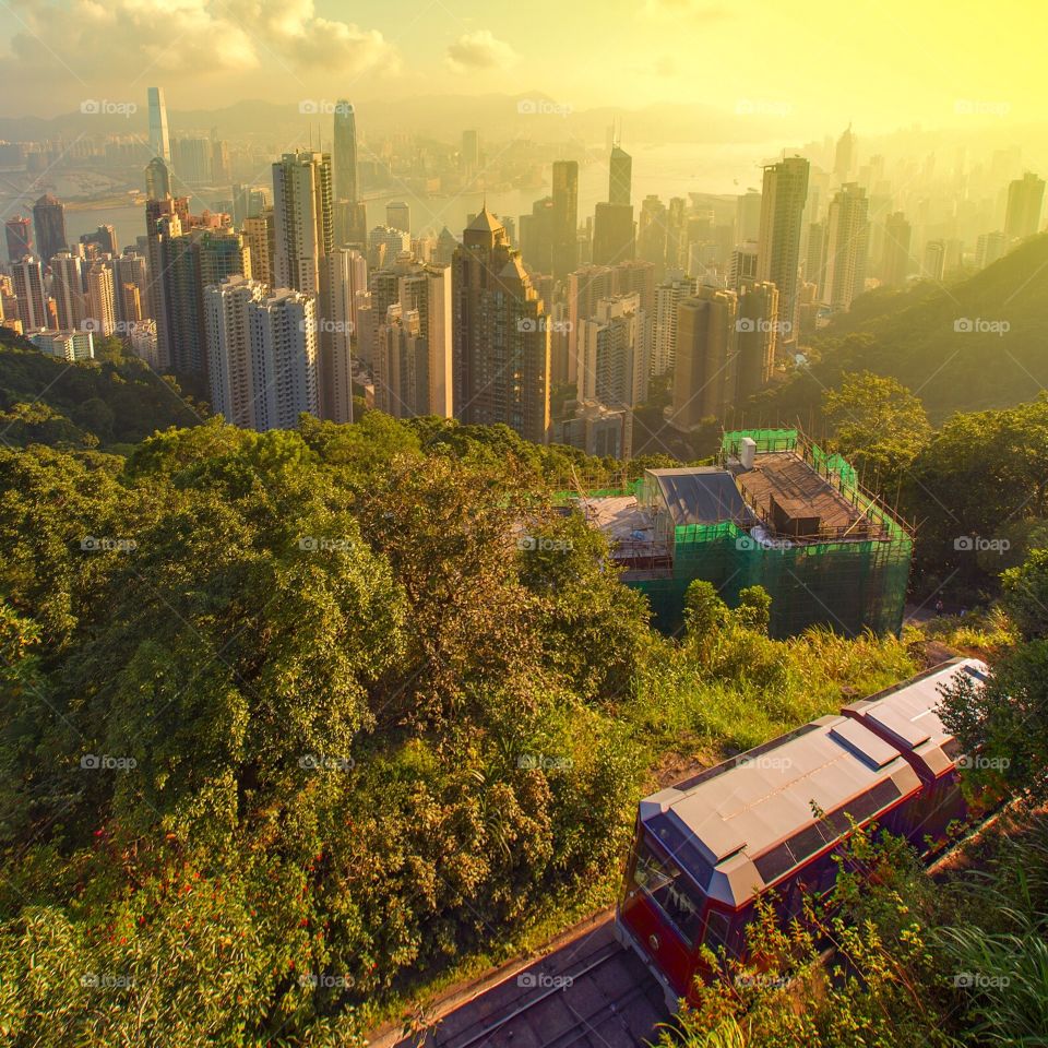 Winter sunrise over Hong Kong . The winter sun rises and the first tram of the day arrives at Hong Kong's Peak
