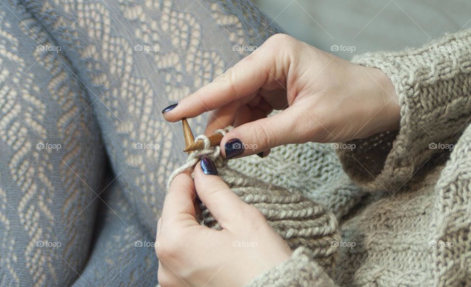 woman knits on knitting needles from woolen threads