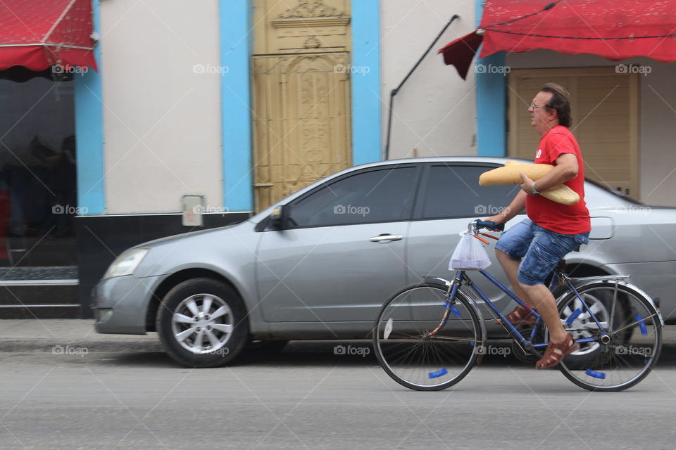 Bicyclist carrying fresh bread in Havana