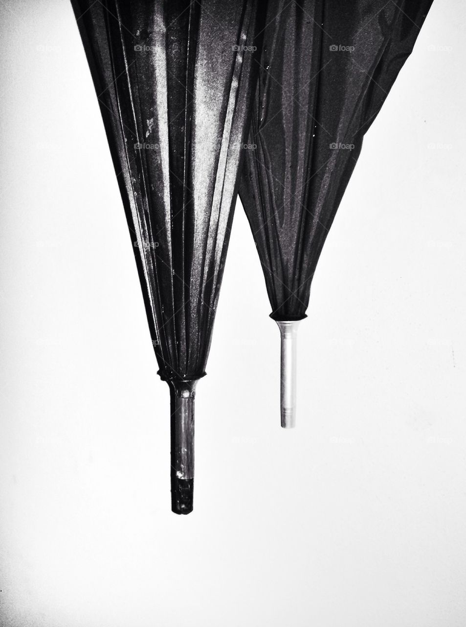 Two umbrellas on white wall