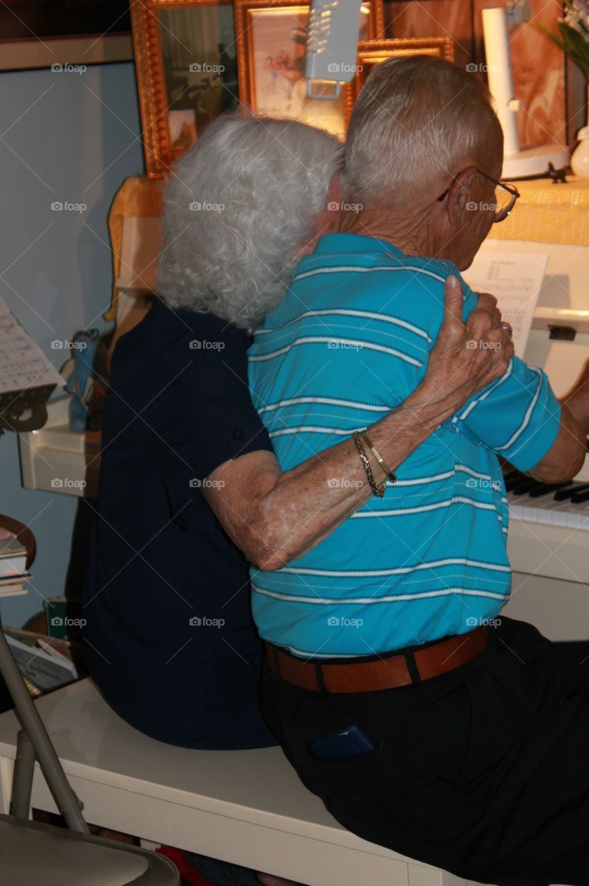 True love and music. Old couple playing piano together