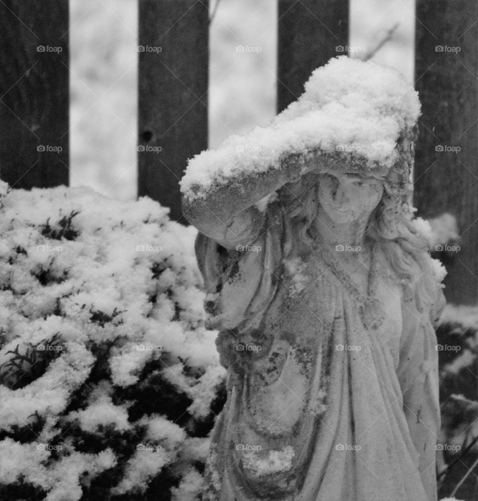 Statue in winter holding off snow