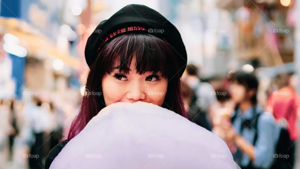 Portrait of a cute young woman covered in bear cotton candy