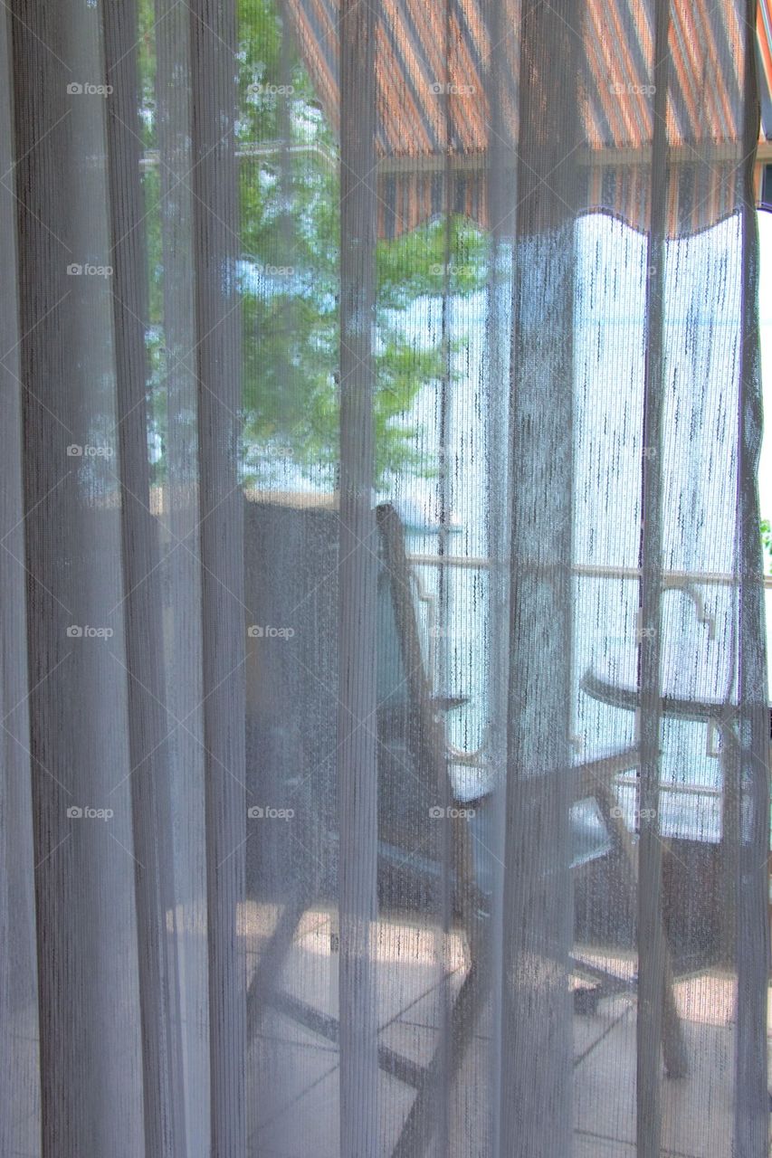 Hotel balcony through the curtains 