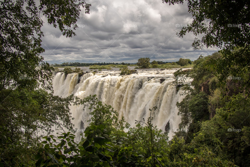 Waterfalls against cloudy sky